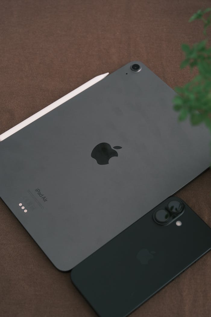 A sleek setup featuring a tablet and smartphone on a brown surface, perfect for tech enthusiasts.